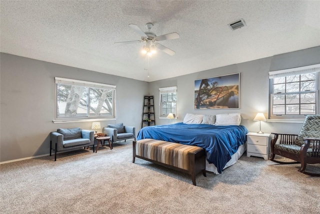 carpeted bedroom with a ceiling fan, visible vents, a textured ceiling, and baseboards