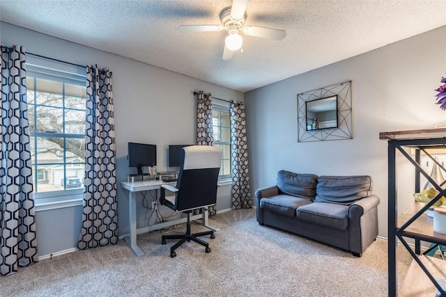 office space featuring a textured ceiling, carpet floors, a ceiling fan, and baseboards