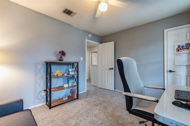 office space with carpet floors, visible vents, a textured ceiling, and baseboards