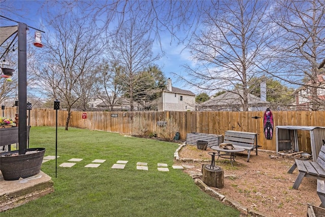 view of yard with a fire pit and a fenced backyard