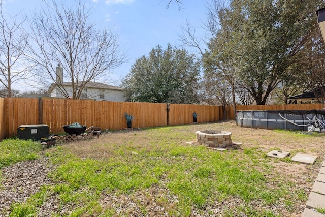 view of yard featuring a fenced in pool, an outdoor fire pit, and a fenced backyard