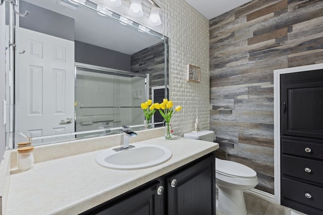 bathroom with a stall shower, visible vents, toilet, tile patterned floors, and vanity