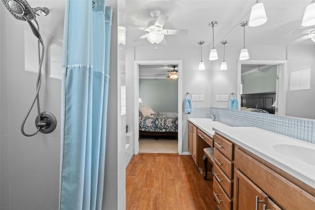 bathroom with double vanity, wood finished floors, connected bathroom, and decorative backsplash