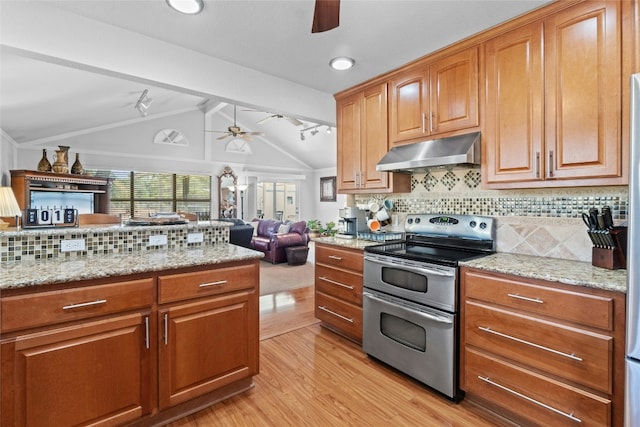 kitchen with light wood finished floors, lofted ceiling with beams, ceiling fan, under cabinet range hood, and double oven range