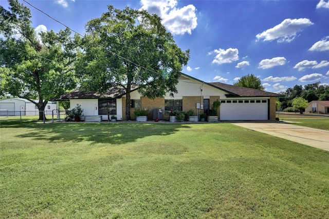 view of front of house with an attached garage, fence, a front lawn, and concrete driveway