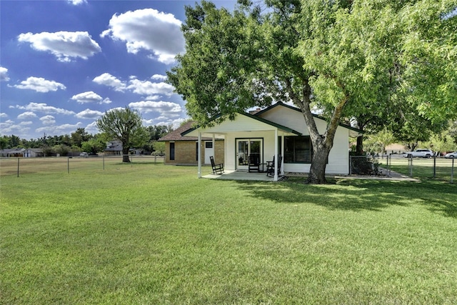 exterior space with a front lawn, a patio area, and fence