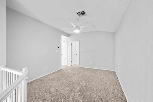 unfurnished bedroom featuring baseboards, visible vents, ceiling fan, vaulted ceiling, and carpet flooring