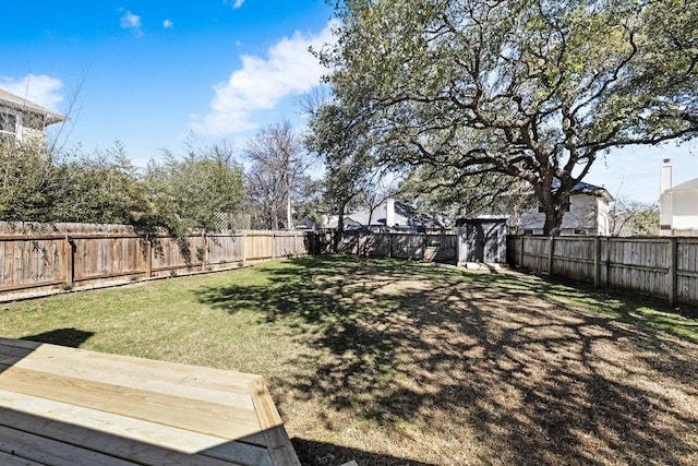 view of yard featuring a shed, an outdoor structure, and a fenced backyard