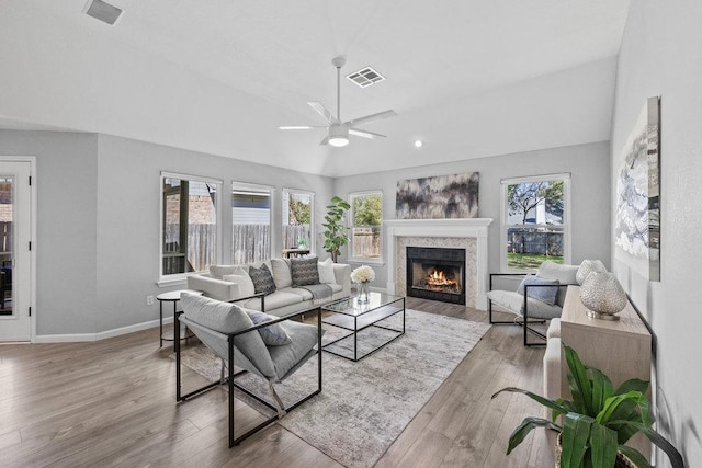 living room featuring visible vents, vaulted ceiling, and wood finished floors