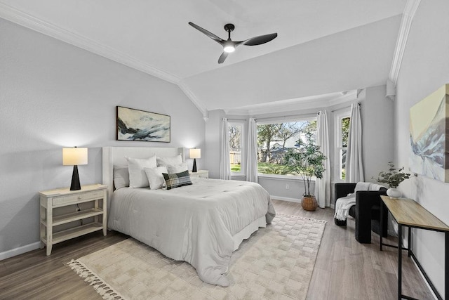 bedroom with crown molding, vaulted ceiling, baseboards, and wood finished floors