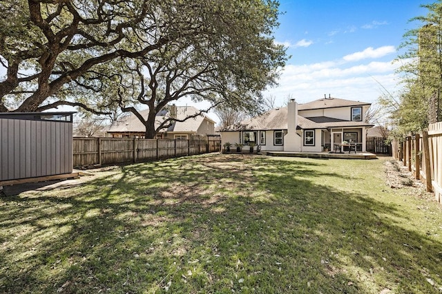 view of yard featuring a storage shed, a fenced backyard, a wooden deck, and an outdoor structure