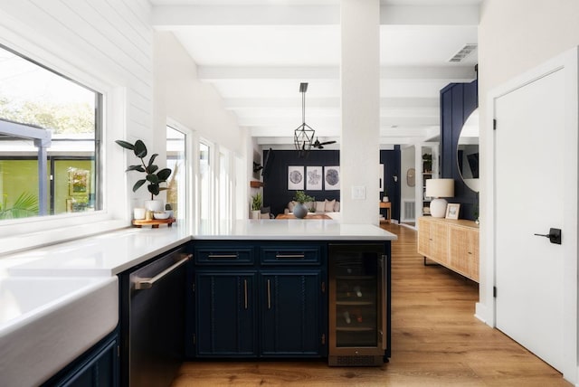 kitchen featuring wine cooler, a peninsula, visible vents, dishwasher, and beamed ceiling