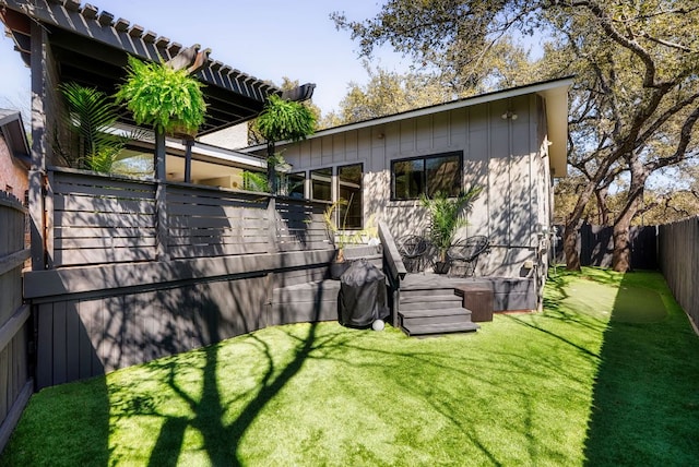 rear view of house featuring board and batten siding, a fenced backyard, and a lawn