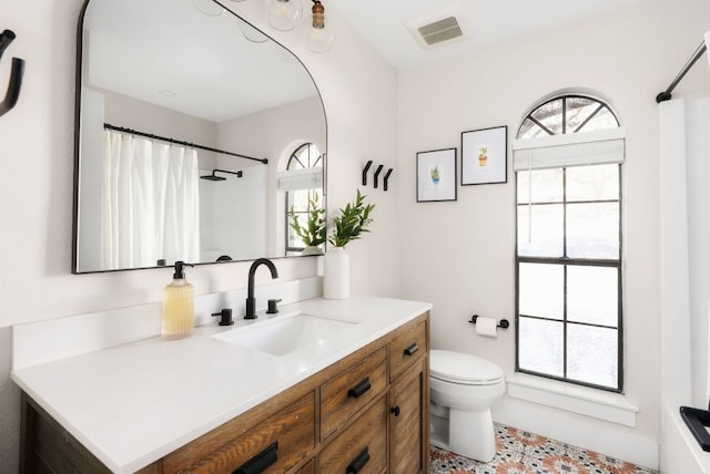 full bathroom featuring toilet, a shower with curtain, visible vents, and vanity