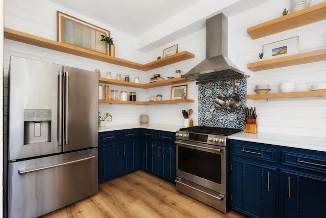 kitchen featuring blue cabinetry, range hood, appliances with stainless steel finishes, and open shelves