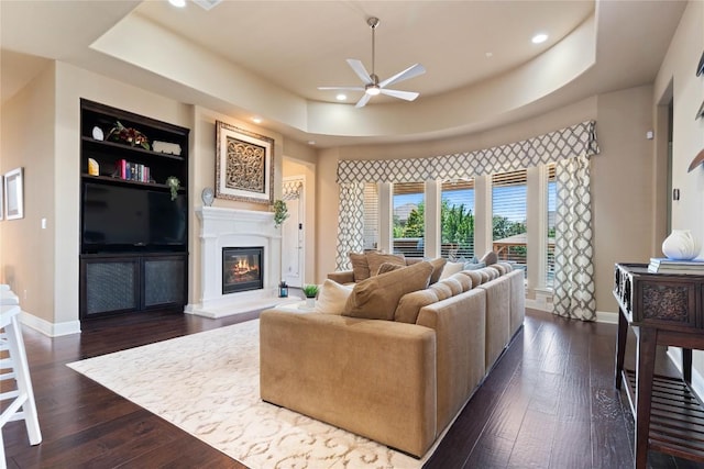 2717 Rain Song Dr, Leander, TX 78641 - living room featuring a raised ceiling, a ceiling fan, baseboards, dark wood-type flooring, and recessed lighting