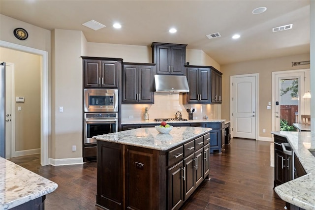2717 Rain Song Dr, Leander, TX 78641 - kitchen with stainless steel appliances, under cabinet range hood, baseboards, decorative backsplash, and recessed lighting