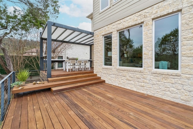 wooden terrace with outdoor dining area and a pergola