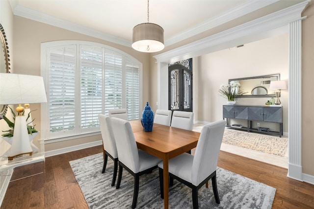 dining room with ornamental molding, baseboards, and wood finished floors