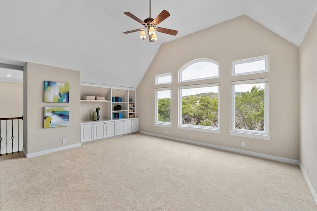 spare room featuring light carpet, high vaulted ceiling, ceiling fan, and baseboards