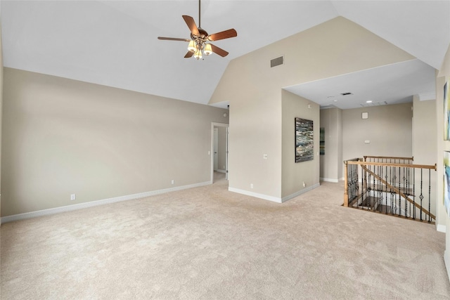 carpeted empty room featuring high vaulted ceiling, visible vents, ceiling fan, and baseboards