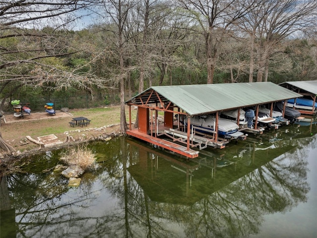 dock area with a water view, an outdoor fire pit, and boat lift