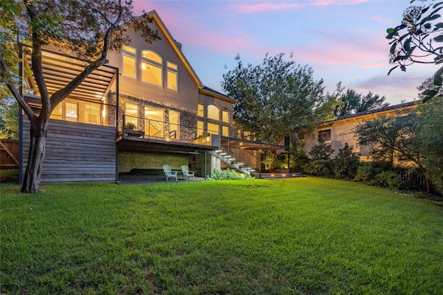 rear view of property featuring stairs, a yard, and a deck