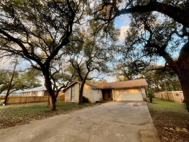 view of front of home with brick siding, fence, driveway, and an attached garage