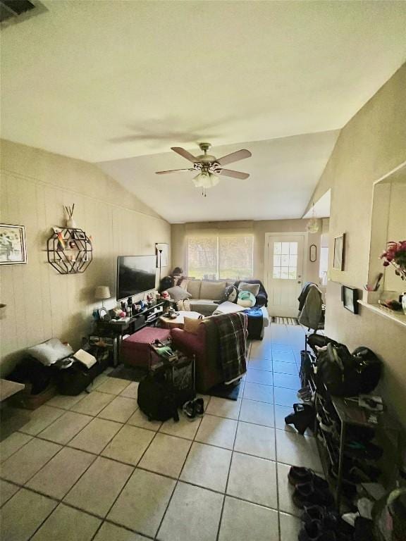 living room featuring lofted ceiling, light tile patterned floors, visible vents, and a ceiling fan