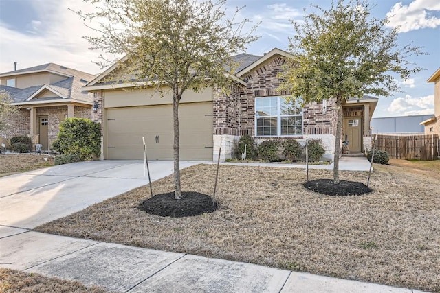 view of front of home with concrete driveway, brick siding, an attached garage, and fence