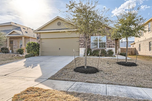 view of front facade featuring a garage, brick siding, driveway, and fence