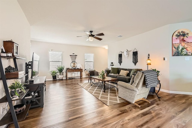 living room with ceiling fan, wood finished floors, visible vents, and baseboards