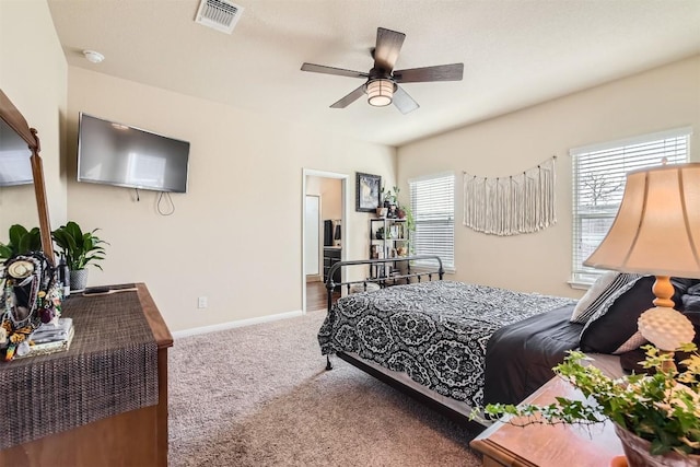 carpeted bedroom with baseboards, visible vents, and a ceiling fan