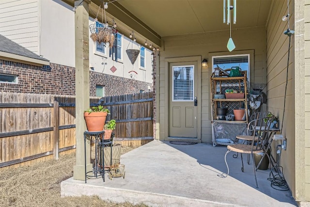 property entrance with a patio and fence