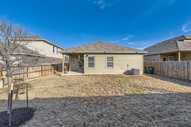 back of house with a fenced backyard, a patio, a lawn, and central AC unit