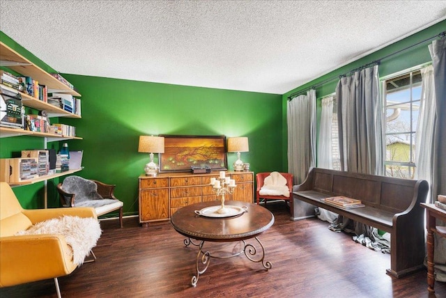 sitting room featuring a textured ceiling, baseboards, and wood finished floors