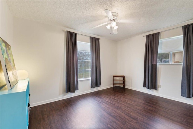 empty room with a ceiling fan, a textured ceiling, baseboards, and wood finished floors