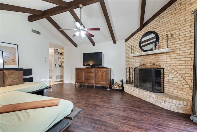 living area featuring visible vents, ceiling fan, wood finished floors, vaulted ceiling with beams, and a fireplace