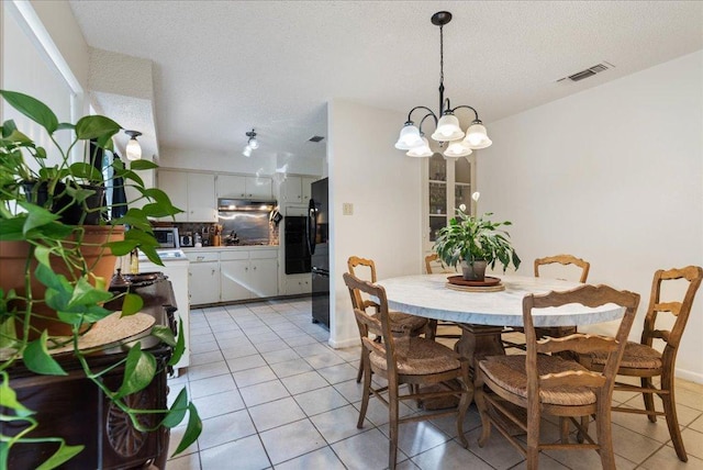 11604 Oak Trl, Austin, TX 78753 - dining space with light tile patterned floors, a chandelier, and a textured ceiling