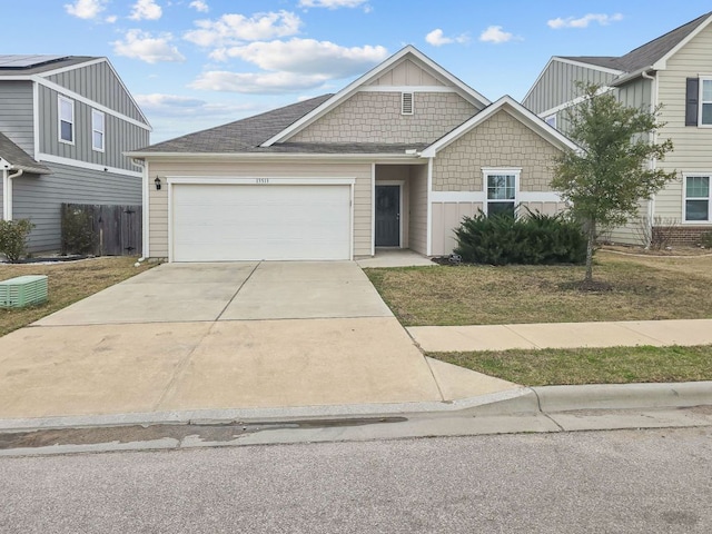 view of front facade featuring driveway, a shingled roof, an attached garage, and fence