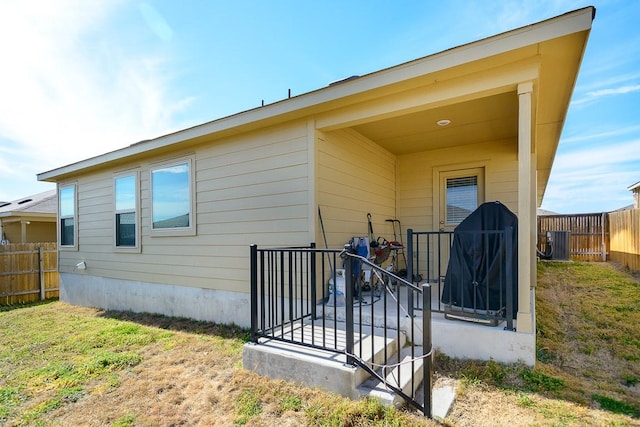 back of property featuring central air condition unit and fence