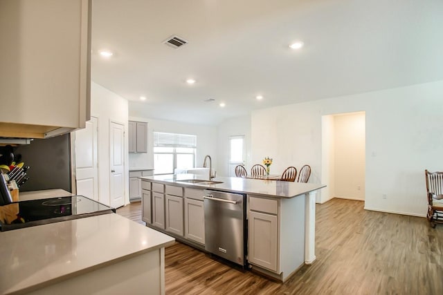 kitchen featuring light wood-style flooring, gray cabinetry, a sink, visible vents, and dishwasher