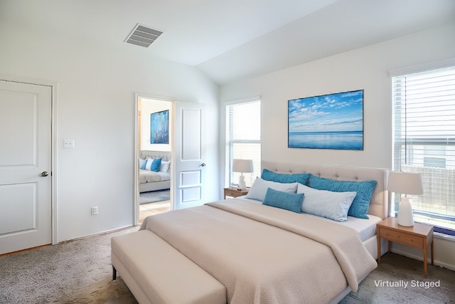 carpeted bedroom featuring lofted ceiling and visible vents