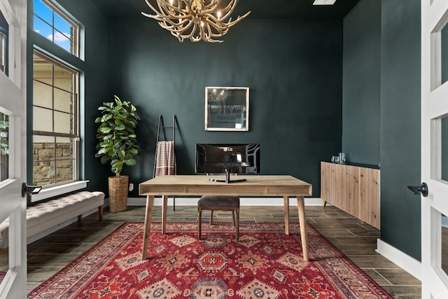 home office with wood tiled floor, a notable chandelier, and baseboards