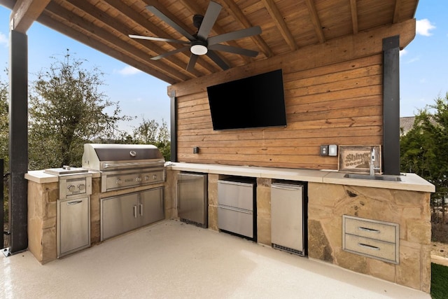 view of patio / terrace featuring a sink, an outdoor kitchen, a grill, and a ceiling fan