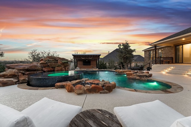 view of swimming pool featuring a pool with connected hot tub and a patio area