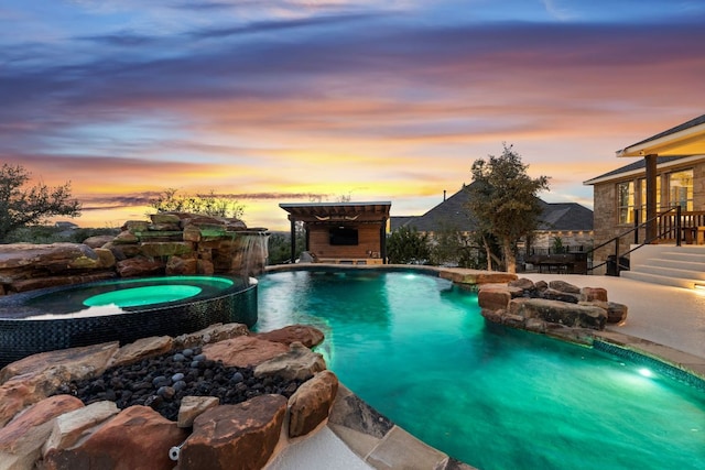 pool at dusk featuring an in ground hot tub and an outdoor pool