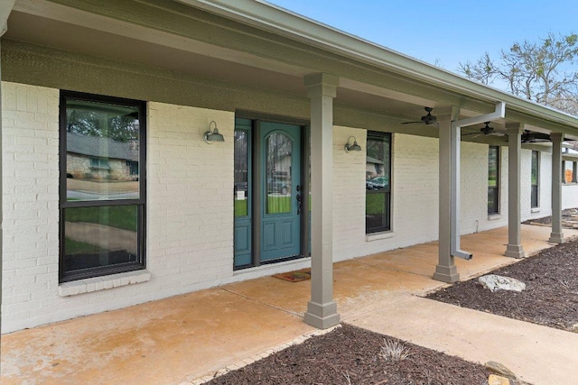 view of exterior entry with covered porch and ceiling fan