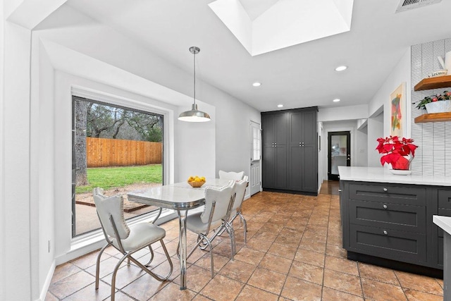 dining area with a skylight, baseboards, and recessed lighting