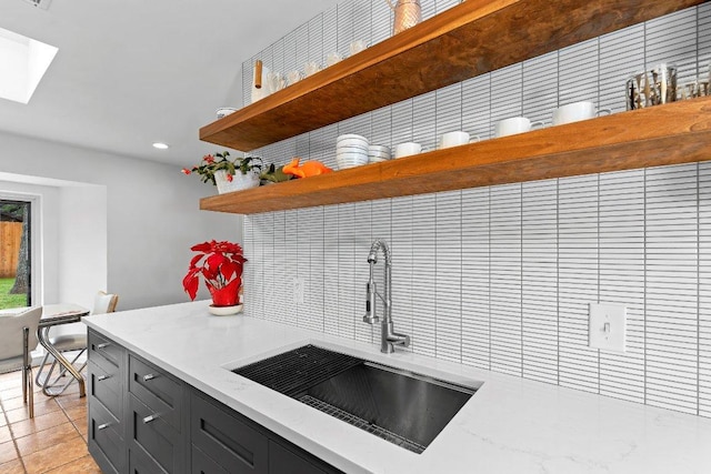 kitchen featuring a sink, light stone countertops, open shelves, backsplash, and recessed lighting